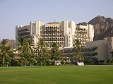 Muscat 05 Al Bustan 03 Outside View Of Hotel Opened in 1985, the Al Bustan Palace InterContinental Muscat hotel has built a reputation as one of the best hotels in the Middle East and one of the finest hotels in the world. Situated eight kilometres from the downtown business district, the hotel is nestled on the coast surrounded by a dramatic mountain backdrop, sea and beach, and set in 200 acres of lush, green gardens. It enjoys spectacular views over the Gulf of Oman.